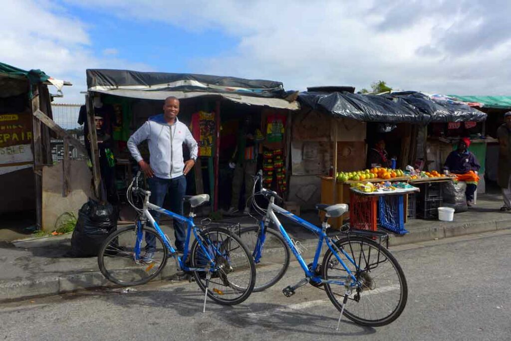 Im Township Langa in Kapstadt steht Siviwe vor Ständen auf dem Markt