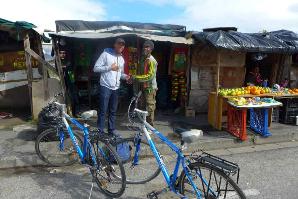 Siviwe kauft im Township Langa in Kapstadt zwei CDs an einem Stand auf dem Markt