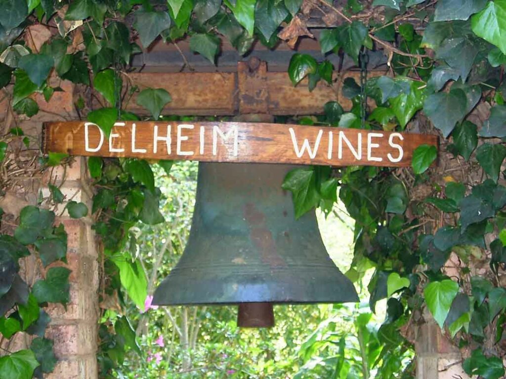 Ein altes Schild zwischen den Weinreben bei Delheim Wines